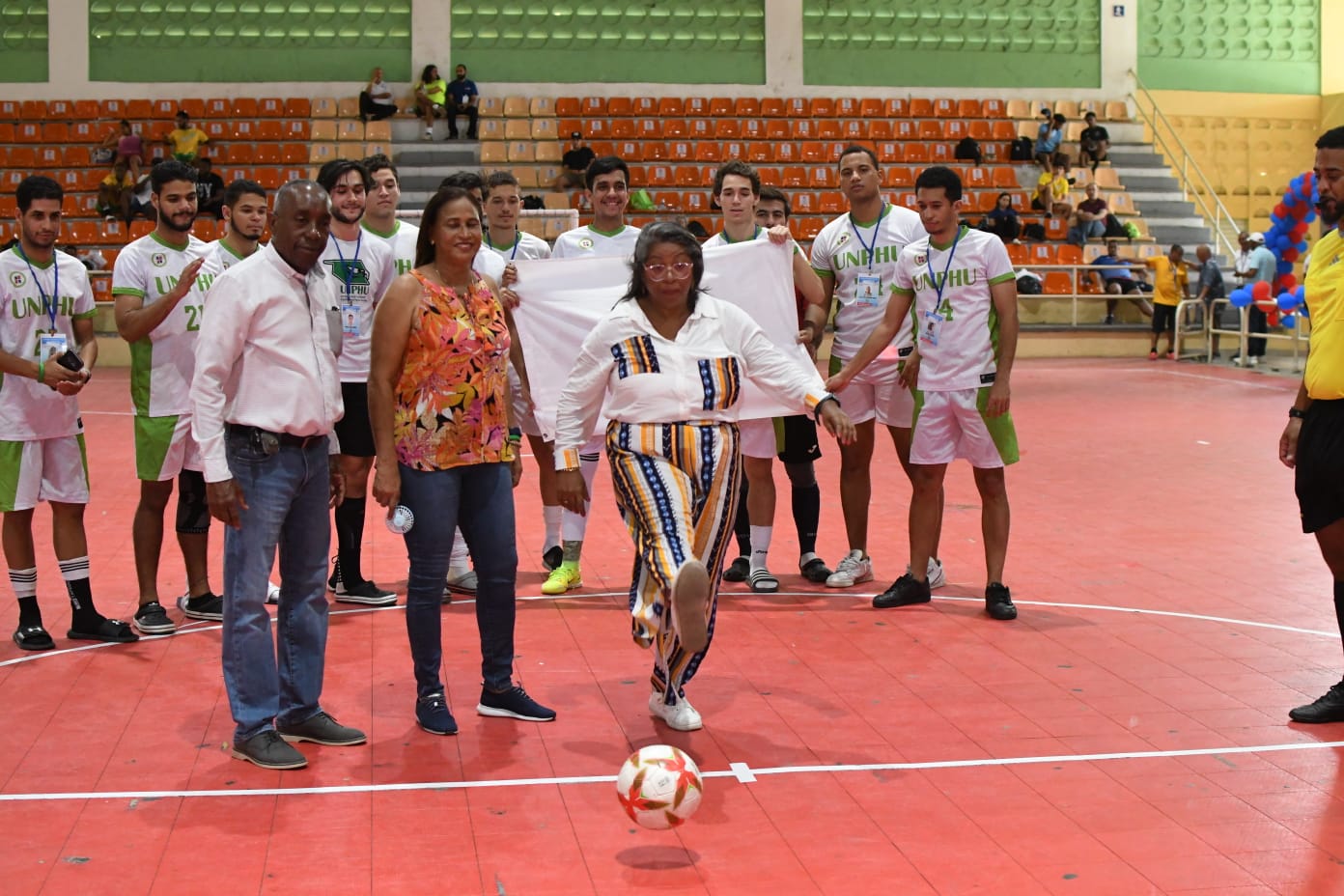 Adrian de Óleo, Decana De Estudiantes de la Universidad Nacional Pedro Henríquez Ureña, en el saque de honor, para dejar abierto el torneo de fútbol sala de los Juegos Universitarios. A su derecha, Aquilina Figueroa de la UNPHU y Roque García.